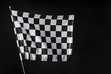 Photo of One racing checkered flag on black background