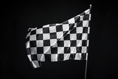 Photo of One racing checkered flag on black background