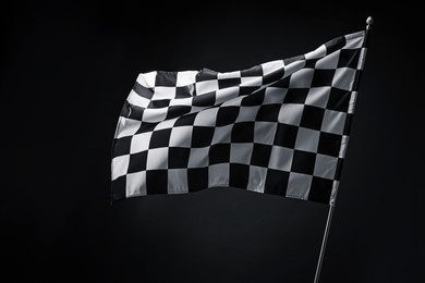 Photo of One racing checkered flag on black background