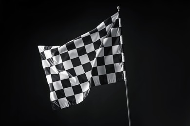 Photo of One racing checkered flag on black background