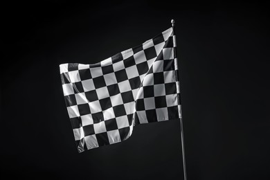 Photo of One racing checkered flag on black background