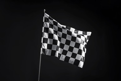 Photo of One racing checkered flag on black background