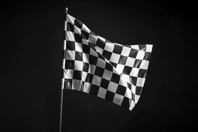 Photo of One racing checkered flag on black background