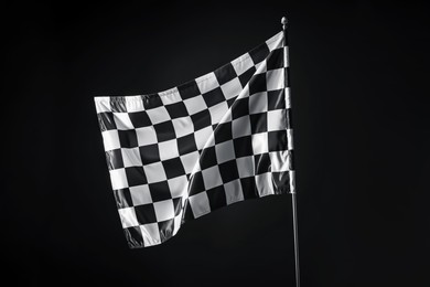 Photo of One racing checkered flag on black background