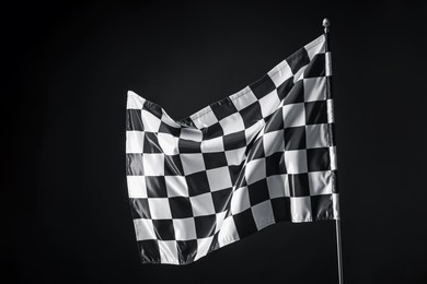 Photo of One racing checkered flag on black background