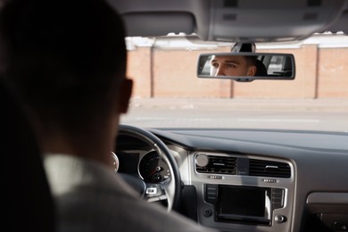 Photo of Driver behind steering wheel of modern car, view from inside