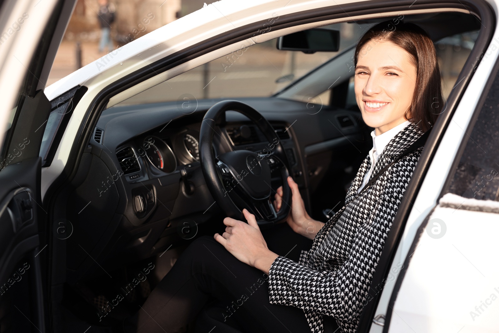 Photo of Driver behind steering wheel of modern car, view from outside