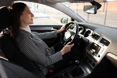 Photo of Driver behind steering wheel of modern car