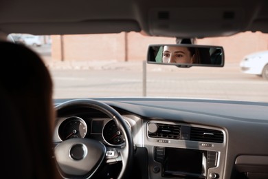 Photo of Driver behind steering wheel of modern car, view from inside