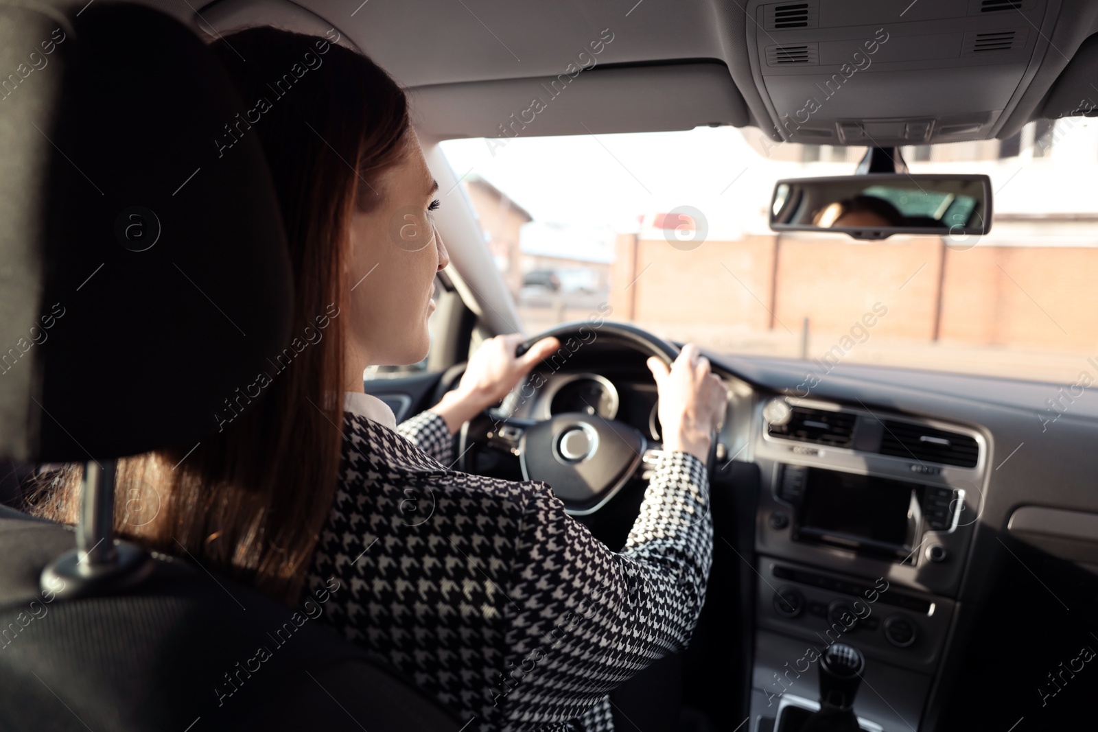 Photo of Driver behind steering wheel of modern car, view from inside