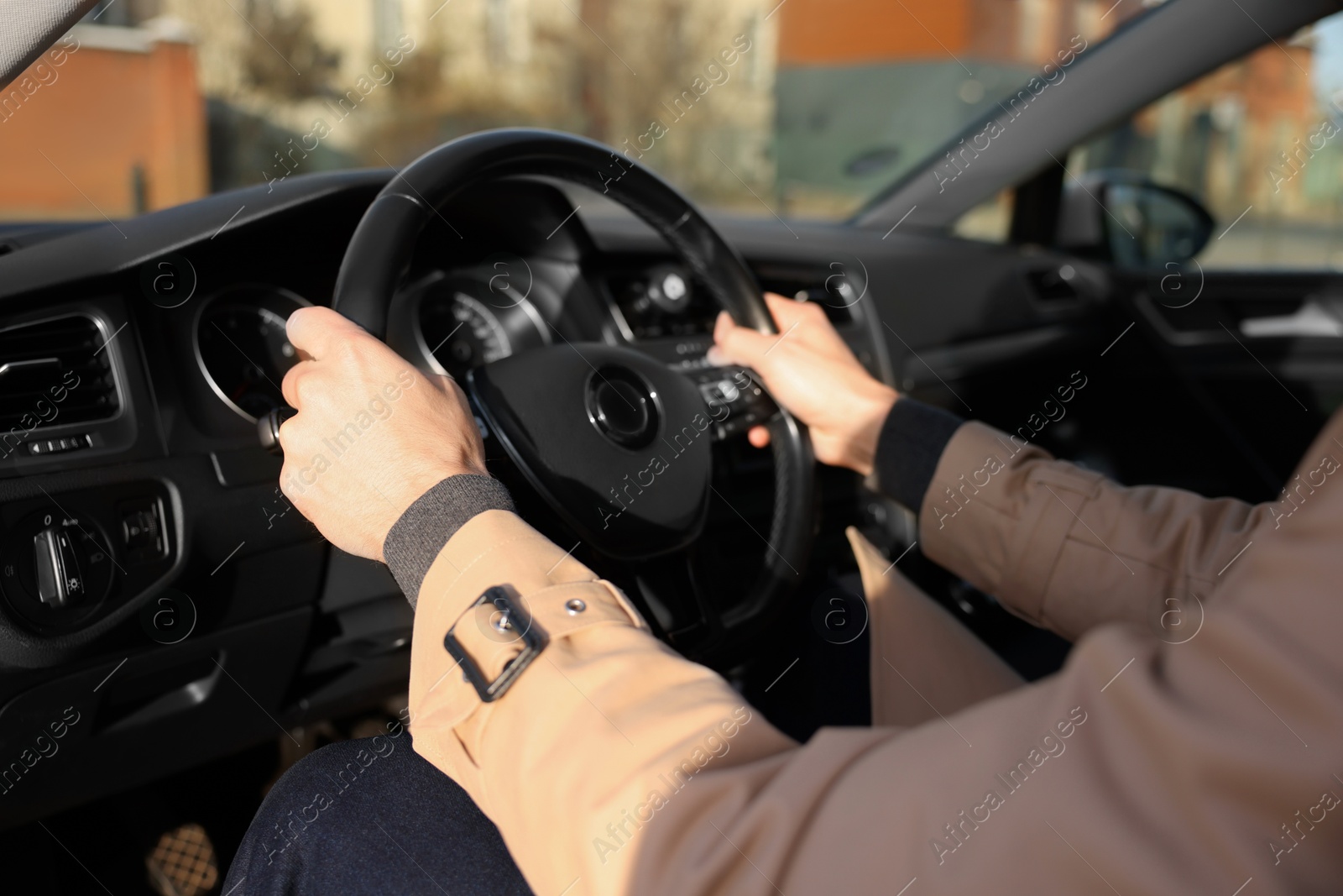 Photo of Driver holding steering wheel while driving car, closeup