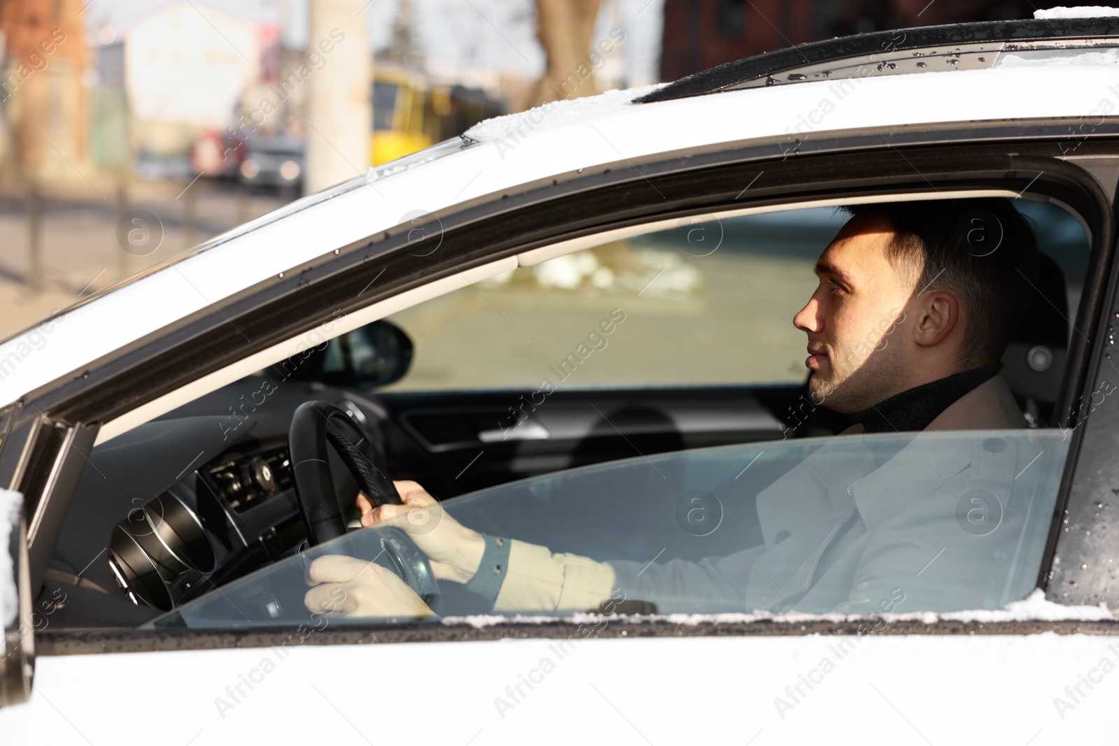 Photo of Driver behind steering wheel of modern car, view from outside