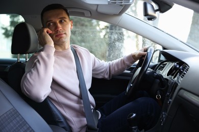 Photo of Driver talking on smartphone while driving modern car