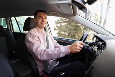 Photo of Driver behind steering wheel of modern car