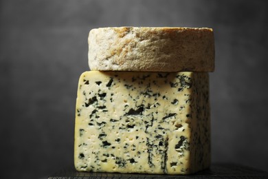 Photo of Fresh cheese on black wooden board against grey background, closeup