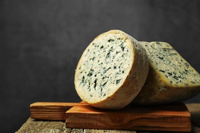 Photo of Fresh cheese on wooden table against grey background, closeup. Space for text