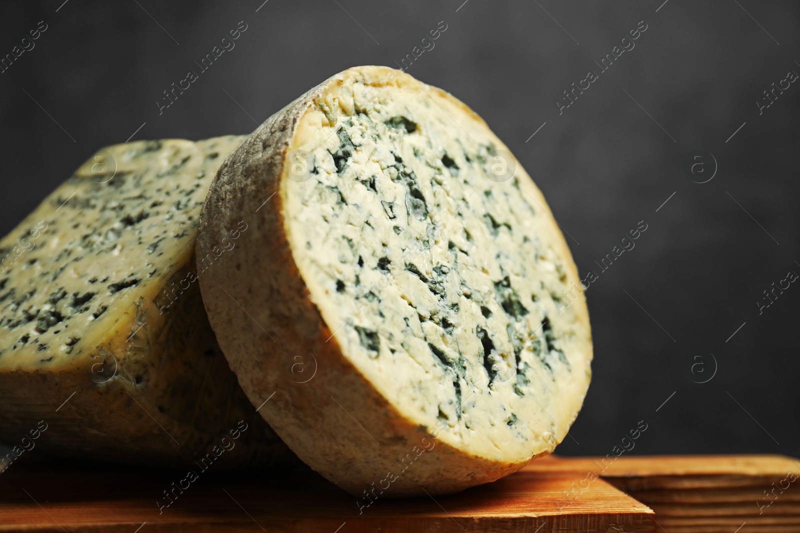 Photo of Fresh cheese on wooden board against grey background, closeup