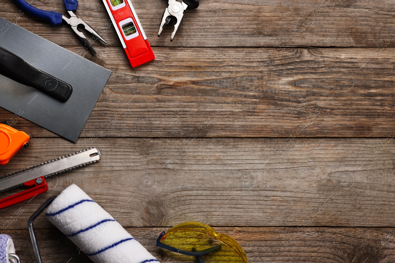 Photo of Different construction materials and tools on wooden table, flat lay. Space for text