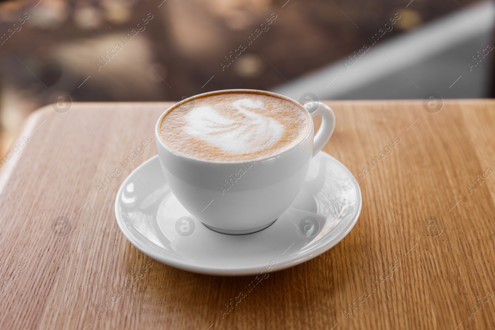 Photo of Cup of aromatic coffee on wooden table in cafe, closeup