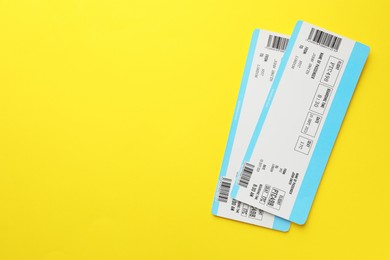 Photo of Travel agency. Flight tickets on yellow background, top view. Space for text