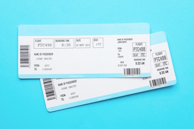 Photo of Travel agency. Flight tickets on light blue background, top view