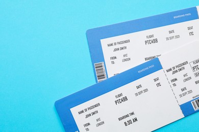 Photo of Travel agency. Flight tickets on light blue background, top view. Space for text