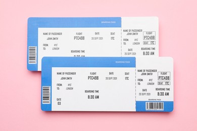 Photo of Travel agency. Flight tickets on pink background, top view