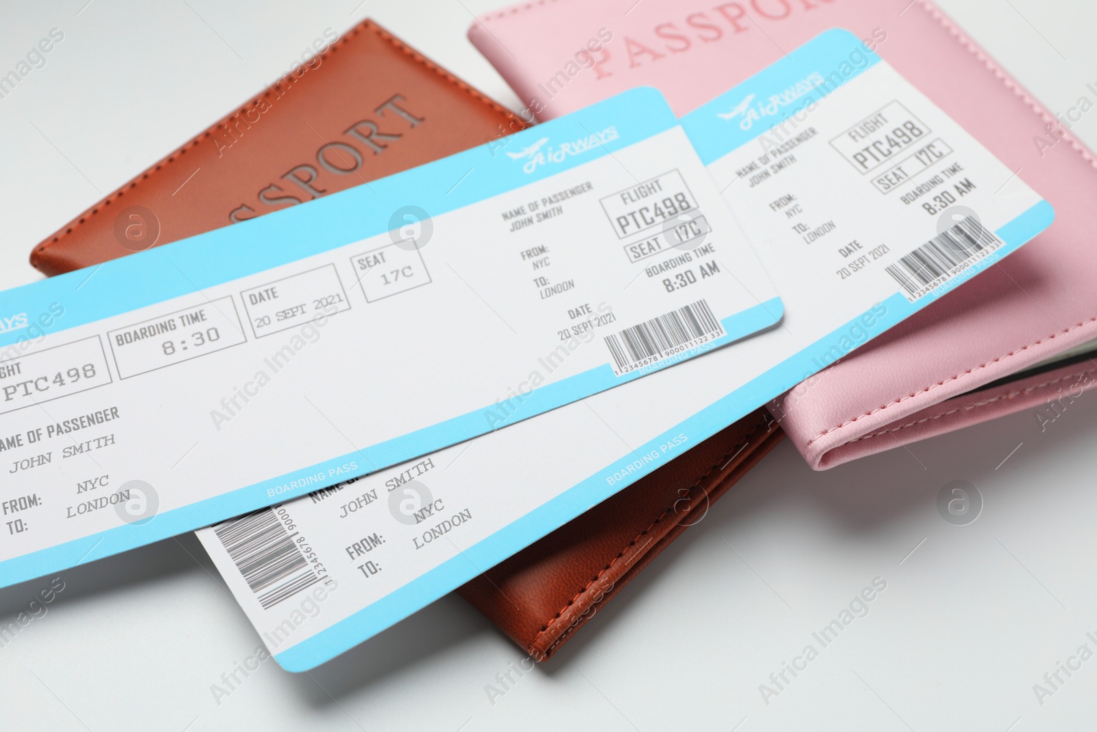 Photo of Travel agency. Flight tickets and passports on light background, closeup