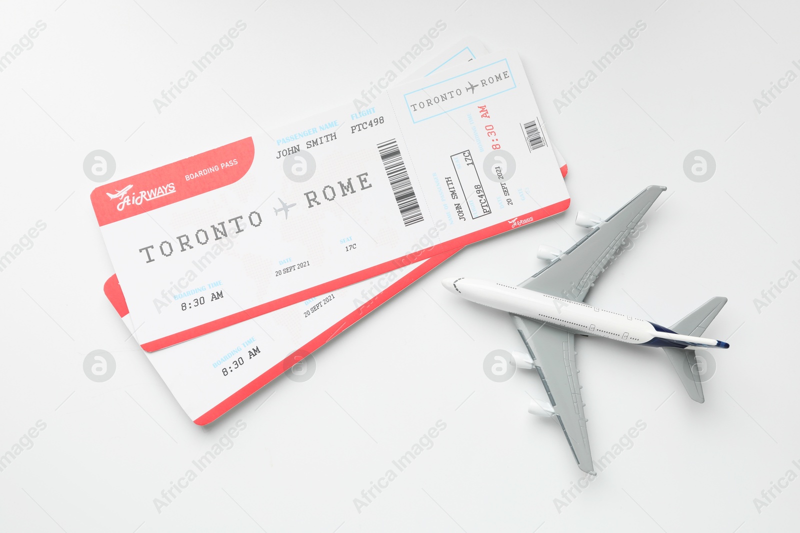 Photo of Travel agency. Flight tickets and plane model on light background, flat lay