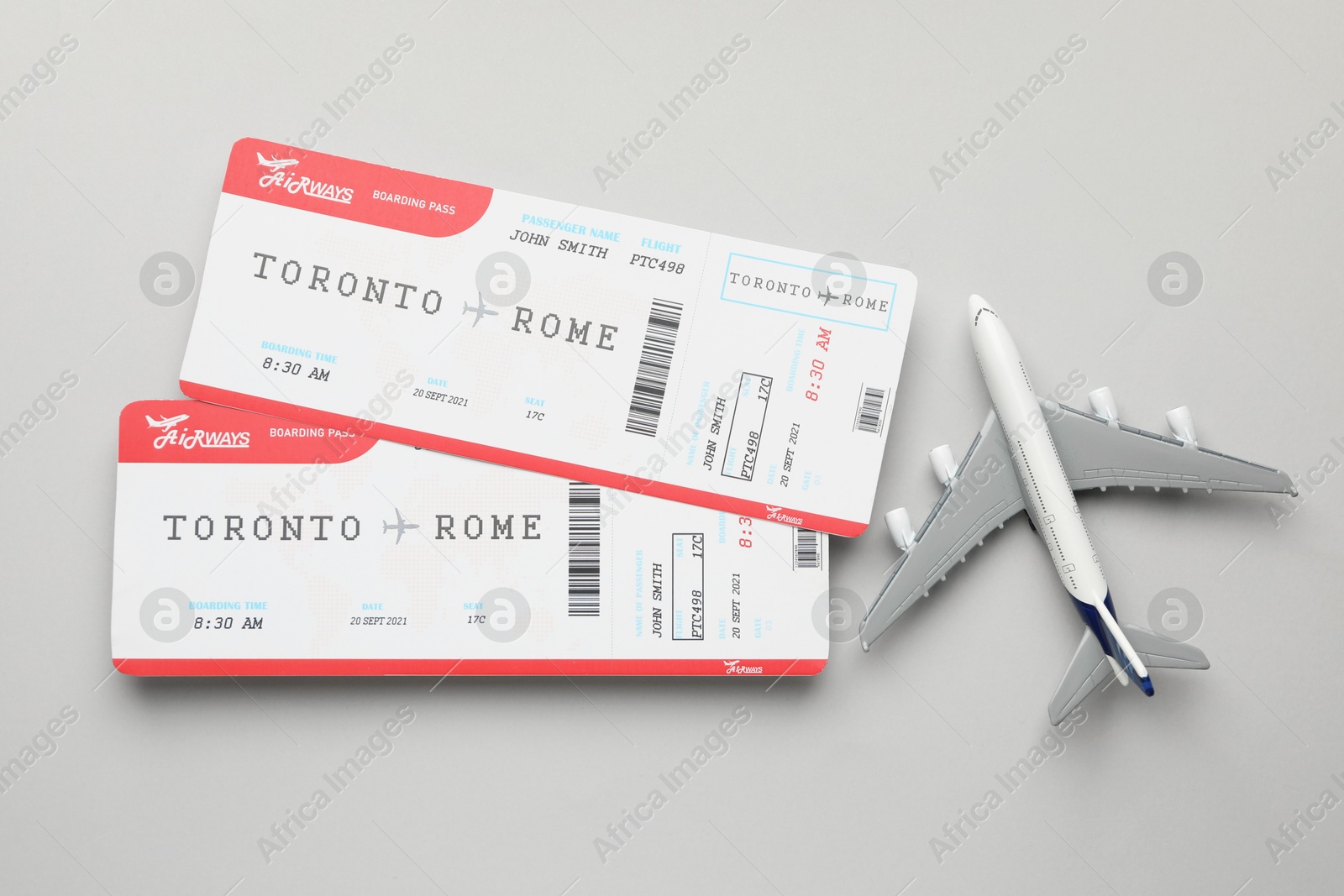 Photo of Travel agency. Flight tickets and plane model on grey background, flat lay