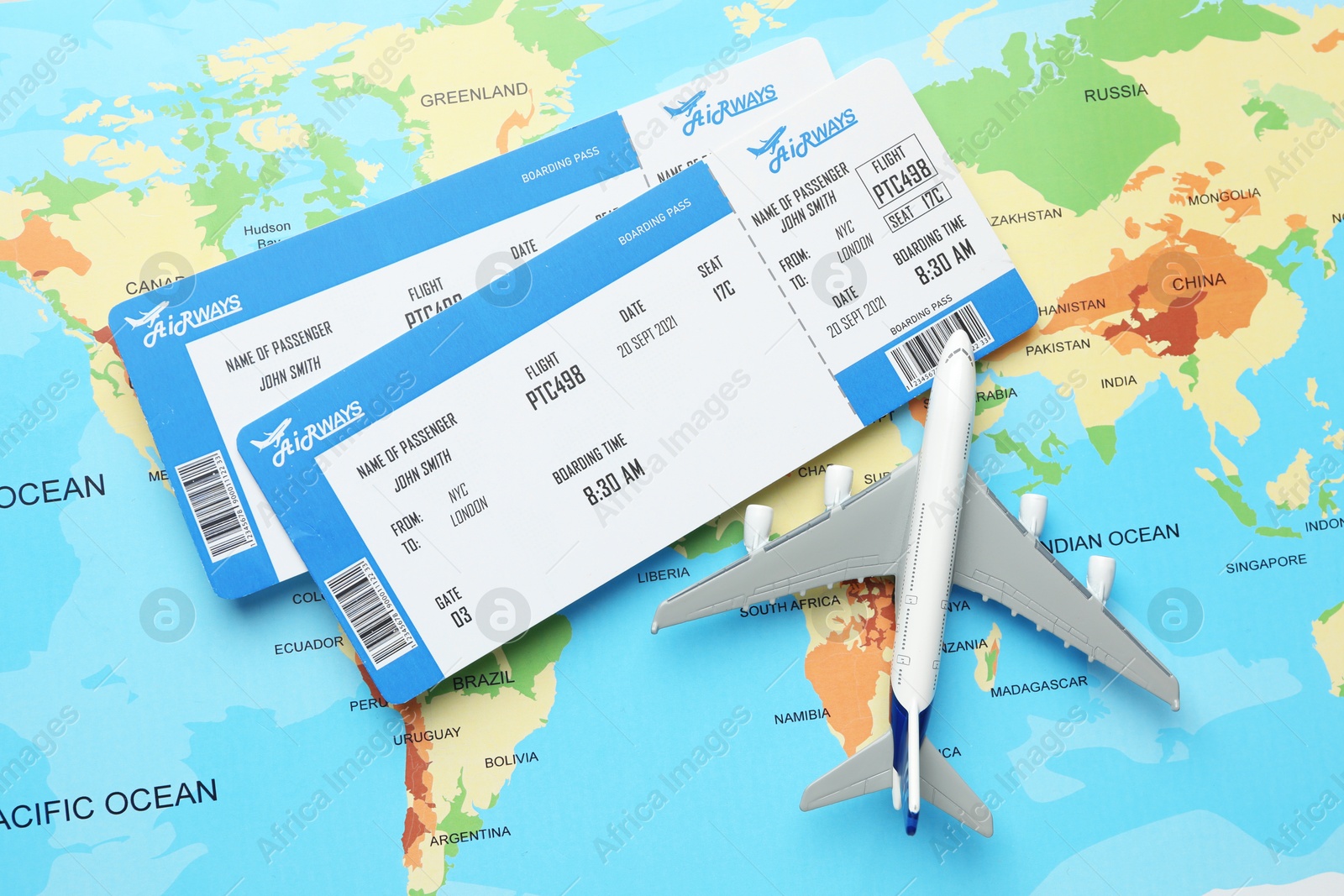 Photo of Travel agency. Flight tickets and plane model on world map, flat lay