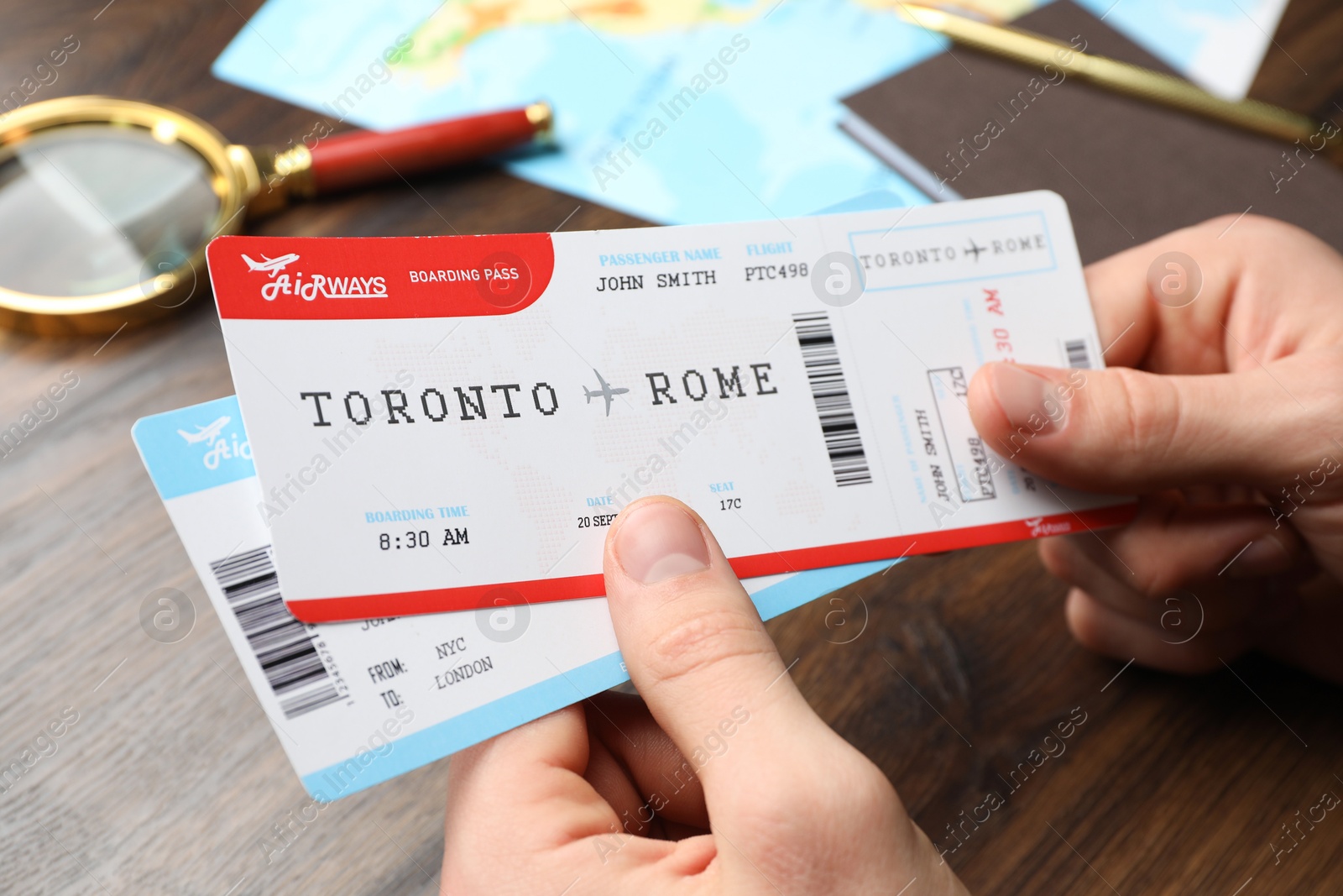 Photo of Travel agency. Man with flight tickets at wooden table, closeup