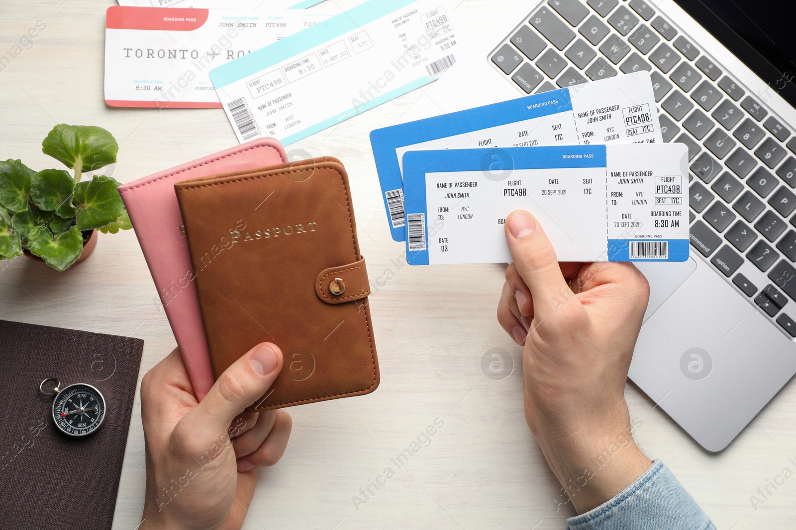 Photo of Travel agency. Man with flight tickets and passports at light wooden table, top view