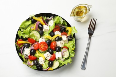 Photo of Delicious fresh Greek salad served on white marble table, flat lay