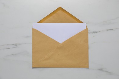 Photo of Kraft paper envelope with letter on white marble background, top view. Mockup for design