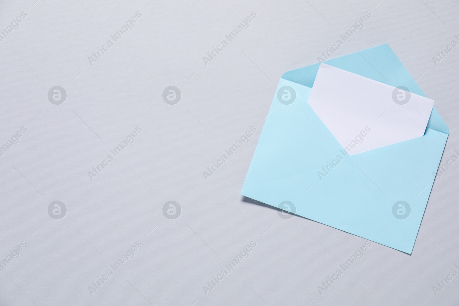 Photo of Paper envelope with letter on gray background, top view. Mockup for design