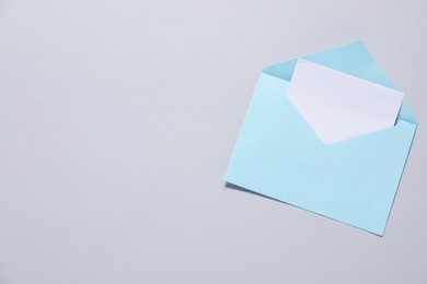 Paper envelope with letter on gray background, top view. Mockup for design