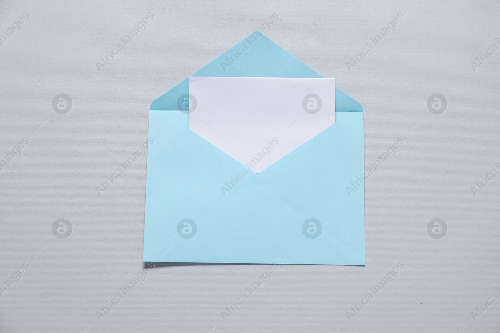 Photo of Paper envelope with letter on gray background, top view. Mockup for design