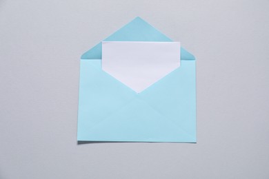 Paper envelope with letter on gray background, top view. Mockup for design