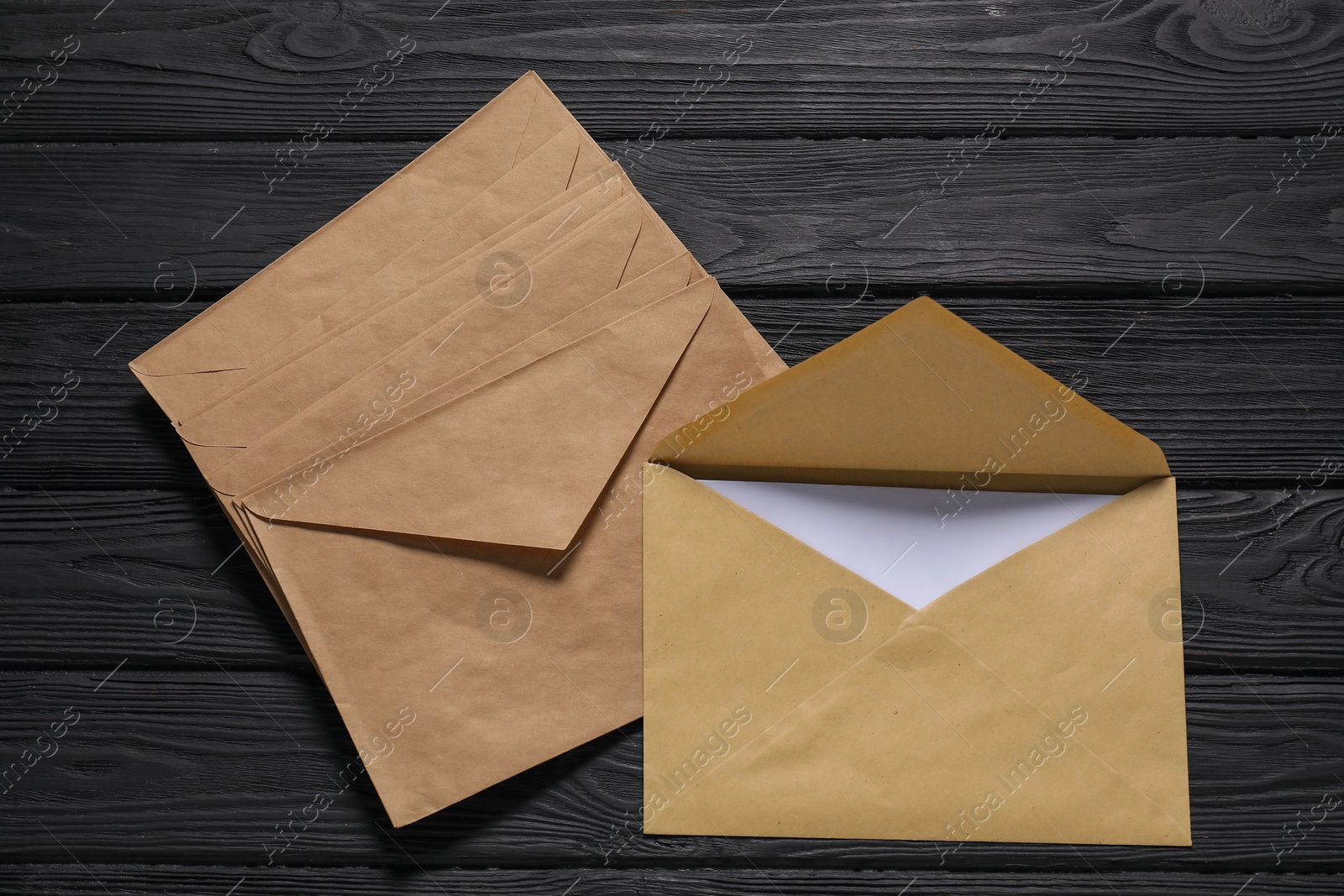 Kraft paper envelopes with letter on black wooden background, top view. Mockup for design Photo of Kraft paper envelopes with letter on black wooden background, top view. Mockup for design