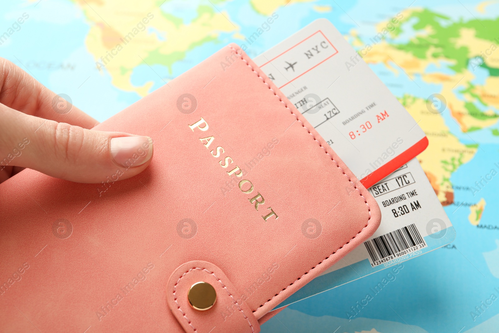 Photo of Person with passport and tickets on world map, closeup