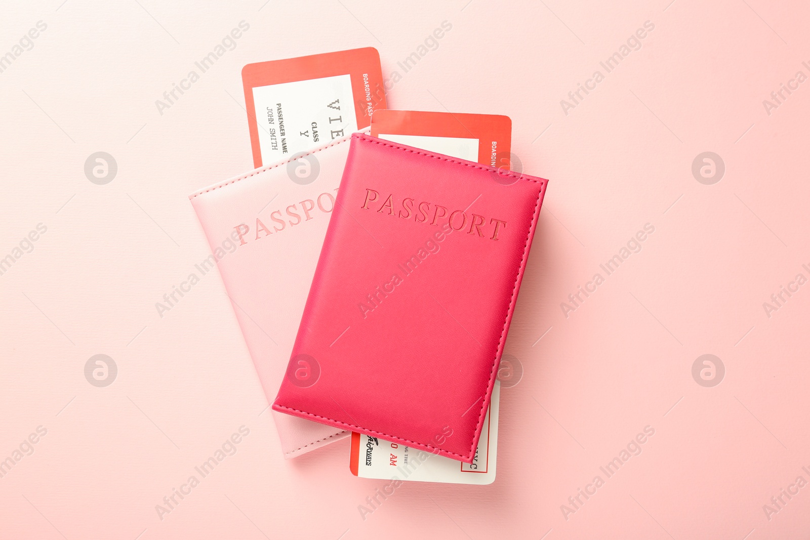 Photo of Passports with tickets on pink background, flat lay