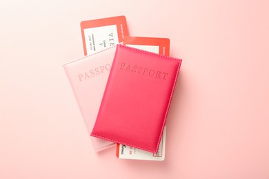 Photo of Passports with tickets on pink background, flat lay