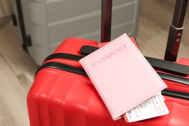 Photo of Passport with ticket and suitcases on floor, closeup