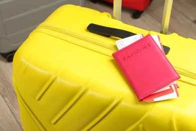 Photo of Passport with tickets on yellow suitcase, closeup