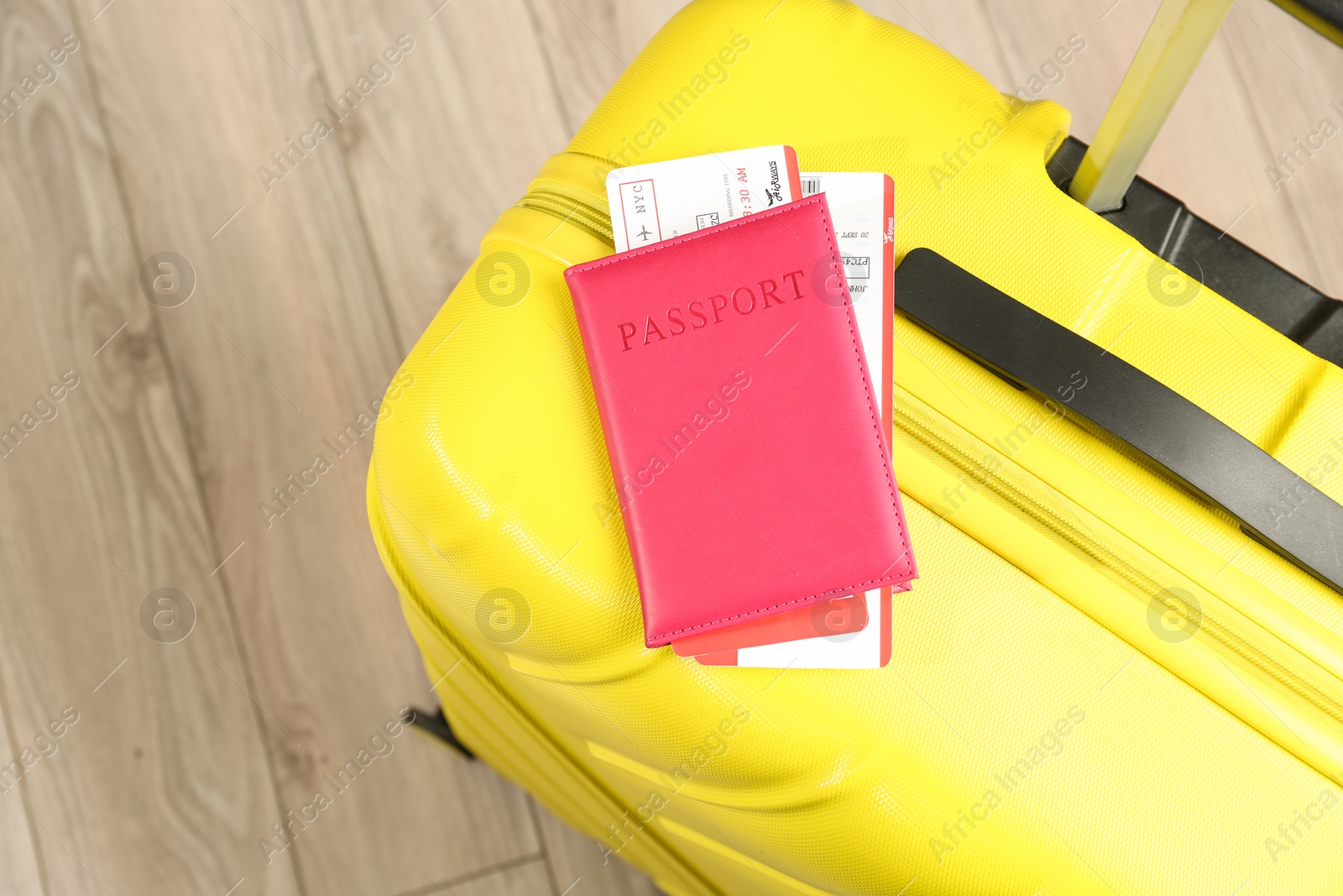 Photo of Passport with tickets and yellow suitcase on floor, top view. Space for text