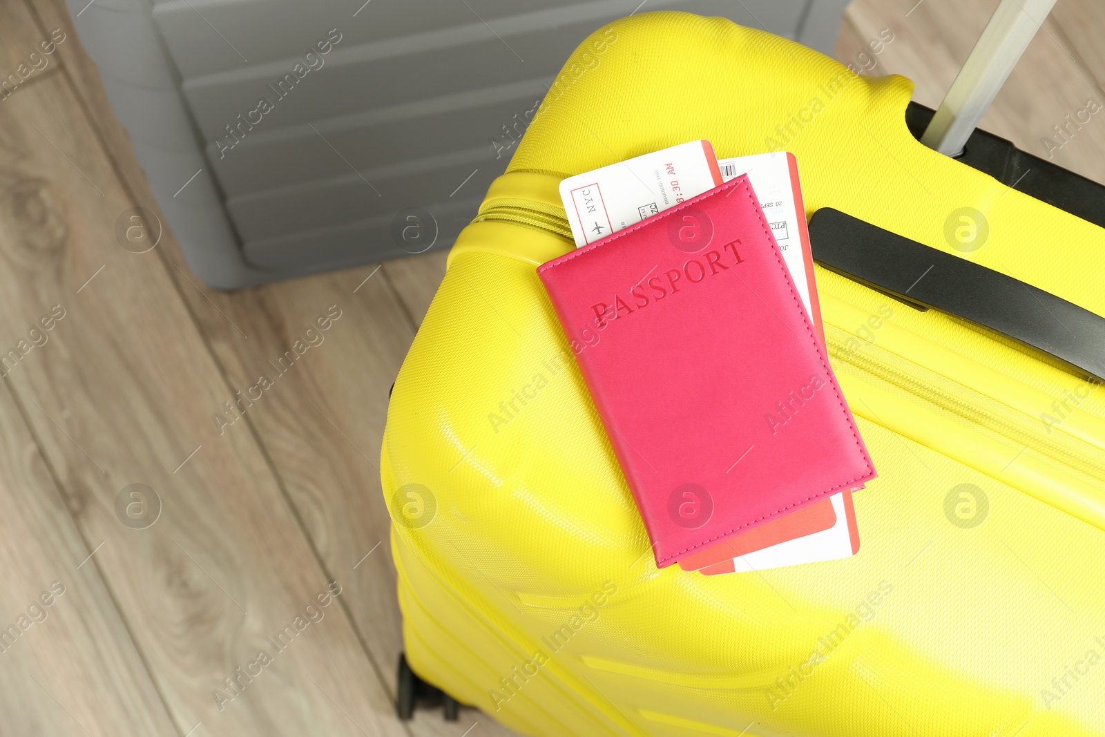 Photo of Passport with tickets and suitcases on floor, above view