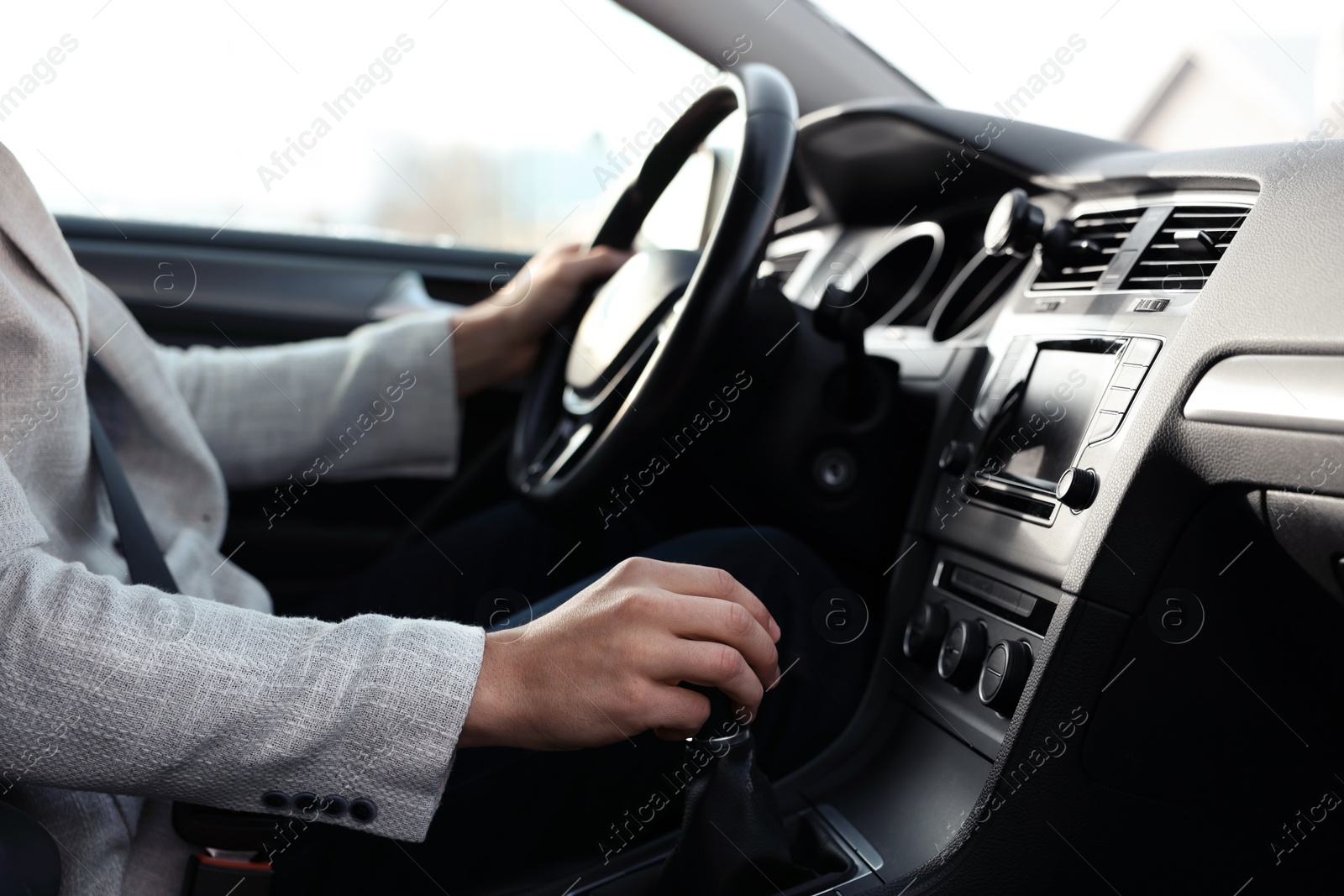 Photo of Driver holding steering wheel while driving car, closeup