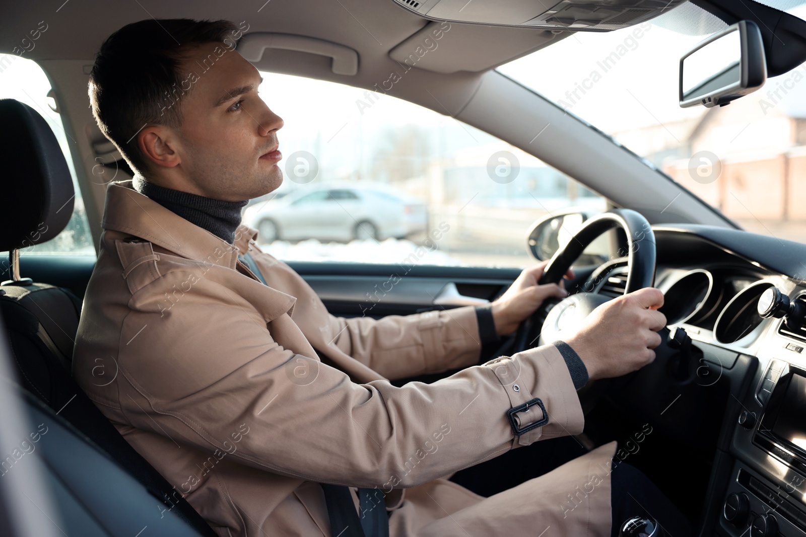 Photo of Driver behind steering wheel of modern car