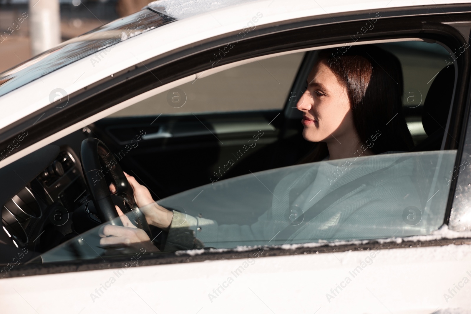 Photo of Driver behind steering wheel of modern car, view from outside